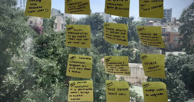 How Might We sticky notes arranged by category on a window